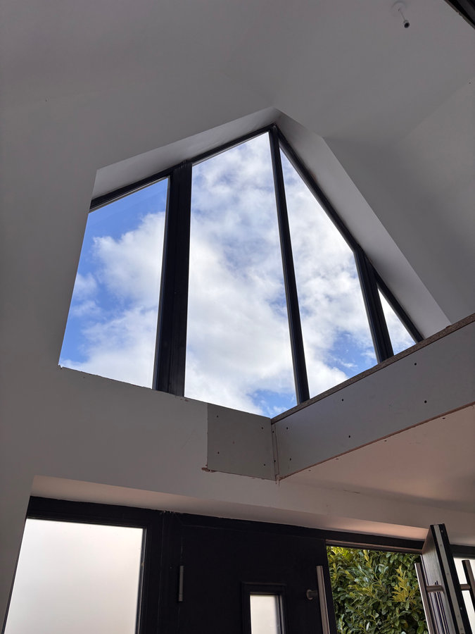 Interior view of high triangular architectural glazing treated by LuxTint